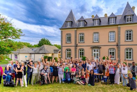 Photo de groupe devant une grande maison